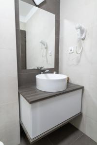 亚斯贝雷尼Manna Aparthotel的浴室设有白色水槽和镜子