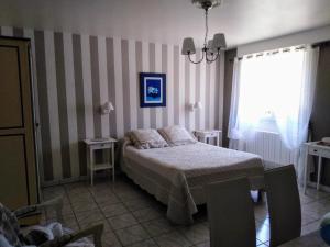 Cénac-et-Saint-JulienLa Touille的一间卧室设有床、两张桌子和一扇窗户