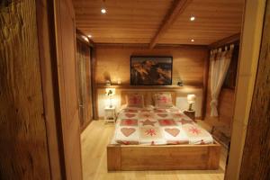 拉克吕萨appartement cozy dans chalet 6 pers voiture 4 roues motrice a dispo的木制客房内的一间卧室,配有一张床