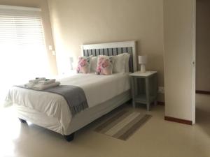 KlawerThe Vine的卧室配有带粉红色枕头的大型白色床
