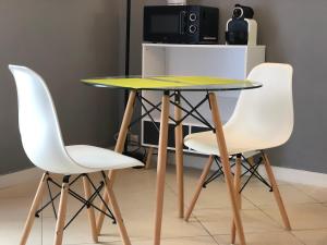 Collonges-sous-SalèveLe Genev Altitud的一张桌子,上面有两把白色的椅子和一张黄色的桌子