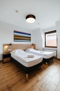 厄尔科Horeka Hotel & SPA的铺有木地板的客房内的两张床