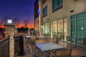 OwassoHoliday Inn Express & Suites - Tulsa Northeast - Owasso, an IHG Hotel的大楼外带桌椅的天井