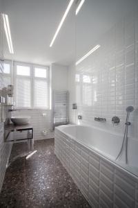 布拉格木栅酒店的白色的浴室设有浴缸和水槽。