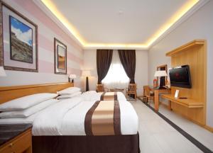 马斯喀特库隆海滩华美达酒店的酒店客房设有一张大床和一台电视。
