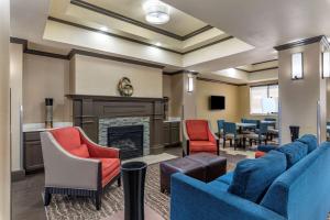 埃尔多拉多Comfort Inn & Suites El Dorado的一间设有蓝色椅子和壁炉的等候室