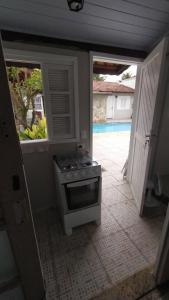 伯迪亚哥Bertioga litoral的一个带炉灶的厨房和一个通往游泳池的门