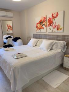 贝纳尔马德纳Luxury Apartamento Minerva Júpiter的卧室配有白色床单和白色大床