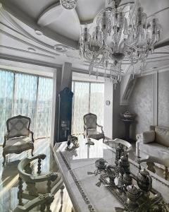 哈尔科夫Hotel "Mandarin Clubhouse"的客厅配有吊灯和桌椅