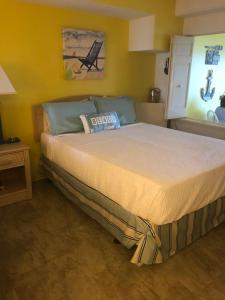 默特尔比奇Beach Colony Ocean Front Executive Suite的黄色客房内的一间卧室配有一张大床
