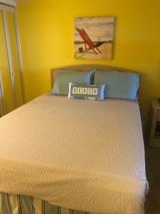 默特尔比奇Beach Colony Ocean Front Executive Suite的卧室里的一张床位,上面有标志