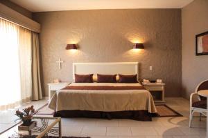 科尔多瓦Hotel Layfer del Centro, Córdoba, Ver的卧室配有一张床,墙上有十字架