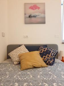 龙基德伊莱焦纳里B&B OASI的一张带枕头的床和墙上的绘画