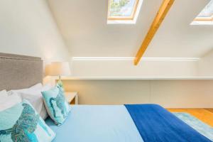 波尔图Hello Porto Firehouse的一间卧室配有一张带蓝色和白色枕头的床