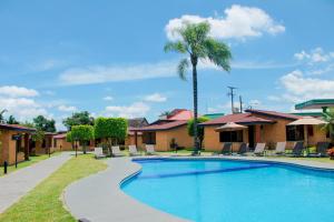 科尔多瓦Villas Layfer, Córdoba, Veracruz, Mexico的一个带椅子和棕榈树的度假村的游泳池