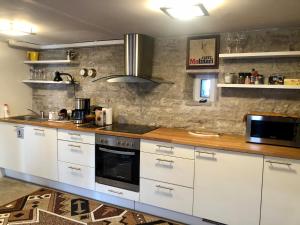 库雷萨雷Kauba 6a apartment的厨房配有白色橱柜和木制台面