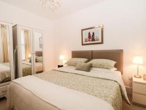 巴克斯顿2B Cavendish Villas的一间卧室配有一张大床和镜子