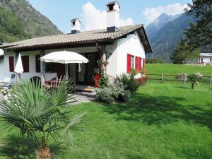 BrioneCasa Marco的白色的房子,有红色的门和草地庭院