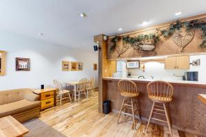 特拉基Cozy Condo in Ski Trails的厨房以及带柜台和椅子的客厅。