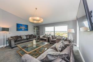 科克River views,Kinsale, Exquisite holiday homes, Sleeps 26的带沙发和玻璃桌的客厅