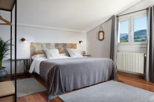 拉萨尔特Casa Rural La Palmera - Landetxea的白色卧室设有一张大床和两个窗户