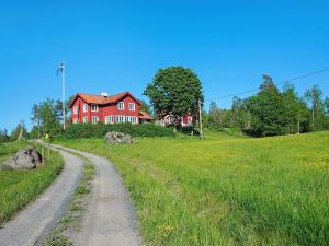 Mellösa5 person holiday home in Mell sa的山坡上一条土路上的红房子