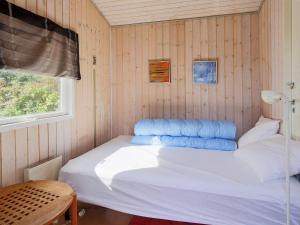 Hornsved6 person holiday home in J gerspris的一间卧室配有一张带蓝色枕头的床。