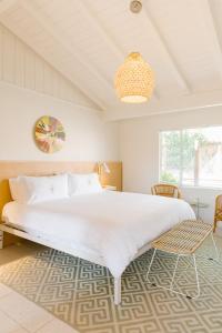 棕榈泉Les Cactus的一间卧室配有一张大床和一个吊灯。