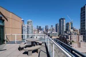 温哥华Grand Park Hotel & Suites Downtown Vancouver的阳台设有2张长椅,享有城市美景。