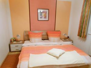 海因岑贝格Appartement Ramona的一间卧室配有带橙色和白色枕头的床