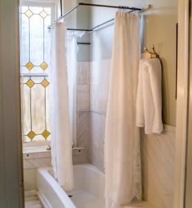 圣乔治The Mulberry Inn -An Historic Bed and Breakfast的浴室配有淋浴帘和浴缸。