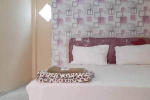 茂物Pakansari Guest Inn Mitra RedDoorz的一间卧室,配有一张带照片的墙壁的床