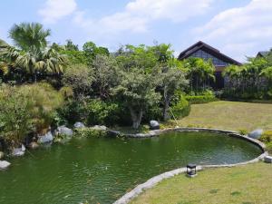茂物Vimala Hill villa and resort - 3 bedrooms的房子后院的一个池塘