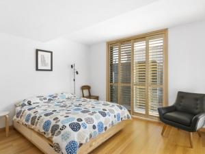 莱伊黑麦漂流木公寓的卧室配有床、椅子和窗户。