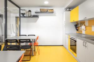 TrbovljeYouth Hostel Trbovlje的厨房铺有黄色地板,配有桌椅