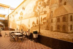 撒马尔罕Cinzano Complex的一座配有桌椅的建筑的侧面壁画