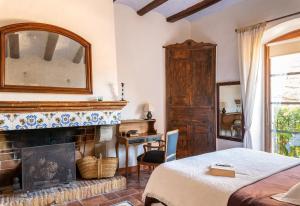 莫奈斯El Palauet de Monells - Adults Only的一间卧室设有壁炉、一张床和镜子