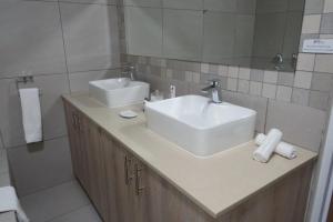 约翰内斯堡道顿旅馆的浴室设有2个水槽和镜子