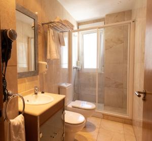 卢戈卢戈城市公寓酒店的浴室配有卫生间、盥洗盆和淋浴。