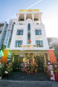 顺化Golden Inn Hotel的前面有鲜花的白色建筑