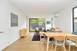 基督城Salisbury Style - Brand new city apartment - Christchurch Holiday Homes的用餐室以及带桌椅的起居室。