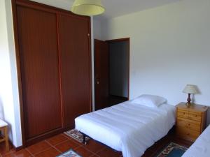 佩纳科瓦Hospedaria Lampião的卧室配有白色的床和木制衣柜。