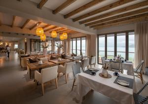 兰格班Shark Bay Hotel & Spa的餐厅设有桌椅和窗户。