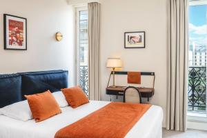 巴黎Hotel Le Friedland的一间卧室配有一张床、一张书桌和一个窗户。