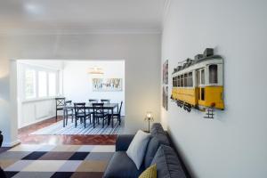 里斯本Casa do Largo Electrico - Cozy and lovely apartment in the city center的客厅配有沙发,墙上有火车