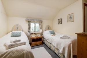 格里姆斯比Marris Cottage的一间卧室设有两张床和窗户。