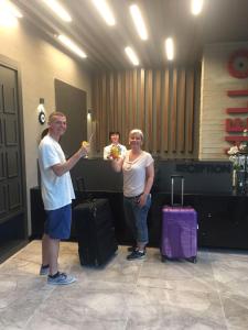 阿拉尼亚Ramira City Hotel - Adult Only (16+)的男人和女人站在一个有行李的房间