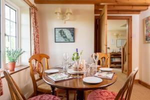 格里姆斯比Marris Cottage的一间带木桌和椅子的用餐室