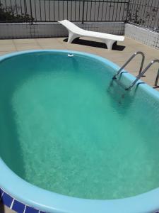 若昂佩索阿Portugal Flat的大型蓝色浴缸,后方配有椅子