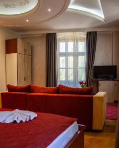 潘切沃Hotel Kutko的一间配备有沙发及电视的酒店客房